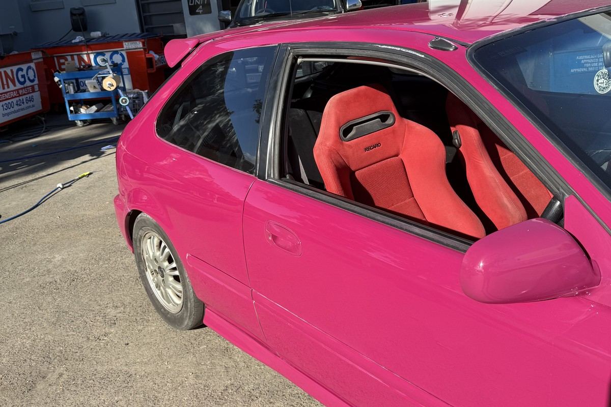 After: the same Honda Civic repaired and resprayed in a custom pink finish