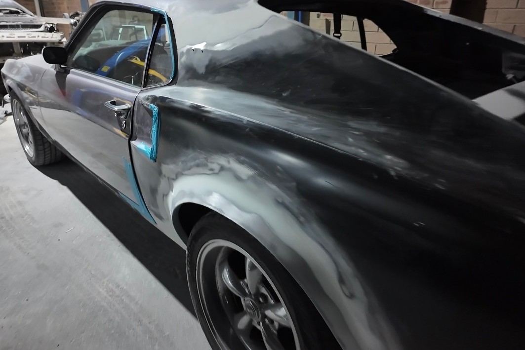 Before: Mustang Mach 1 quarter panel stripped to bare metal and primer during bodywork