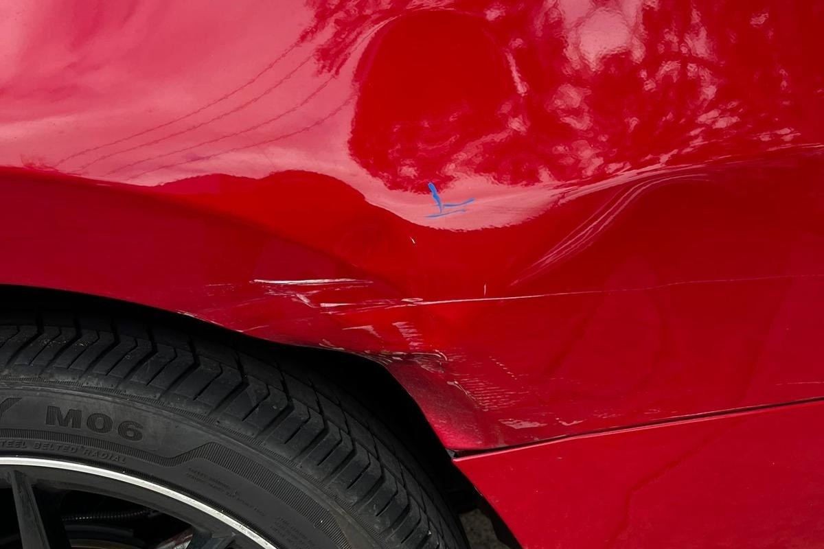 Before: rear quarter panel dented and creased above the wheel arch